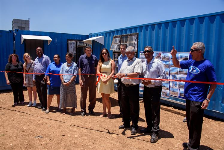 Faizal de Doncker (MP&L Manager, Ford Struandale Engine Plant) does the official ribbon cutting to launch the new wing of the so-called ‘Blue Village’, which now houses 20 families at the Vastrap informal settlement in Booysens Park, Port Elizabeth. The launch was attended by the management team from the Ford Struandale Engine Plant and its associated partners in the project, including the Nelson Mandela Bay Municipality’s Human Settlements Department, non-profit organisation KICK, as well as shipping company Hamburg Süd which donated two of the containers.